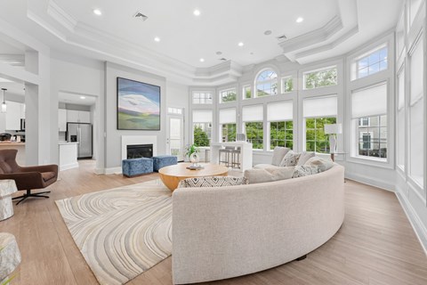 A modern living room with a large sofa and a painting on the wall.