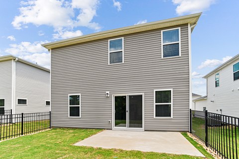 A grey house with a black fence in front.