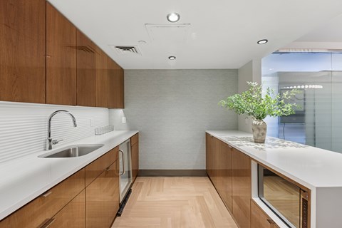 A modern kitchen with wooden cabinets and a white countertop.