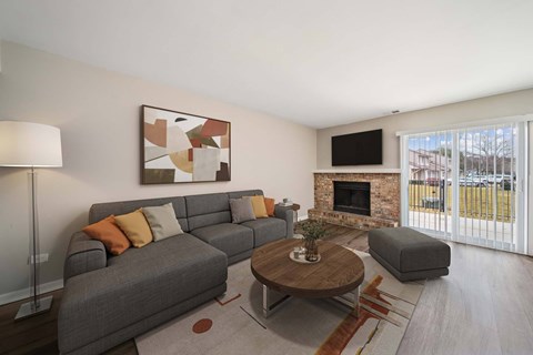 A living room with a grey couch, a coffee table, and a painting on the wall.