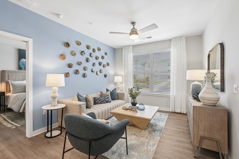 A living room with a grey armchair and a wooden coffee table.