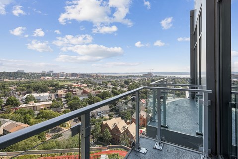 a balcony with a view of a city and a pool