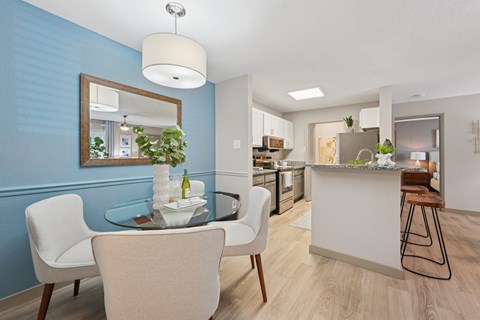 A modern kitchen with a dining table and chairs.