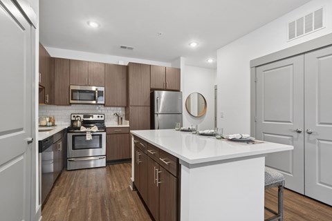 A modern kitchen with a white countertop and wooden cabinets.
