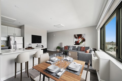 A modern dining room with a wooden table set for a meal.