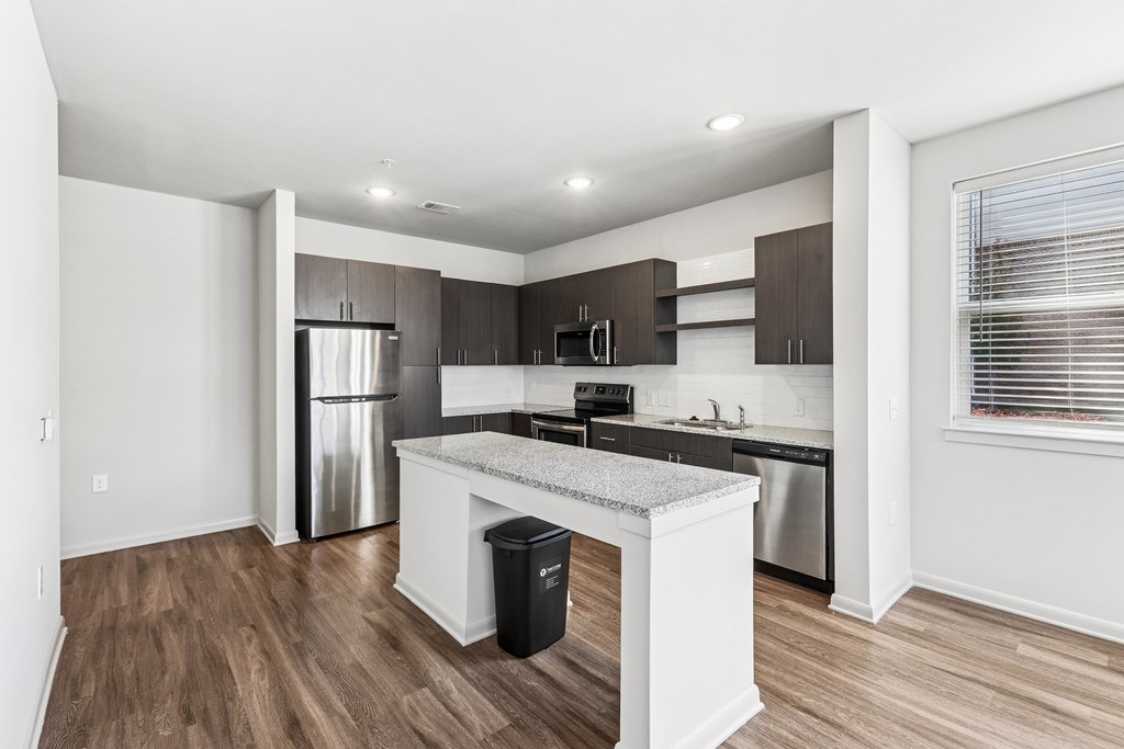 A kitchen with a white island and stainless steel appliances.