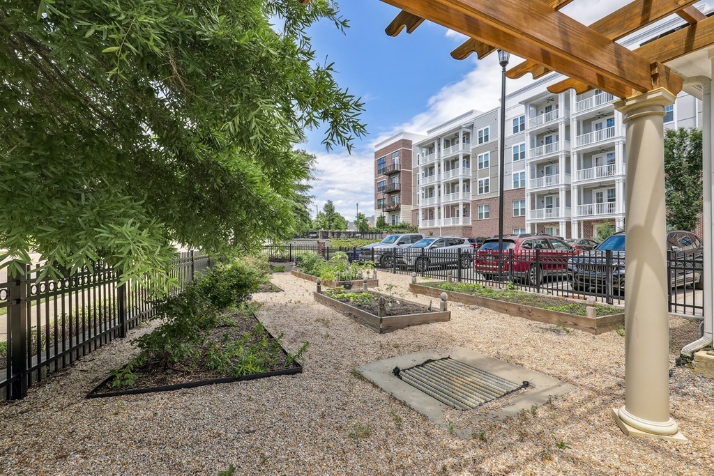 a community garden with a gazebo and trees and a building