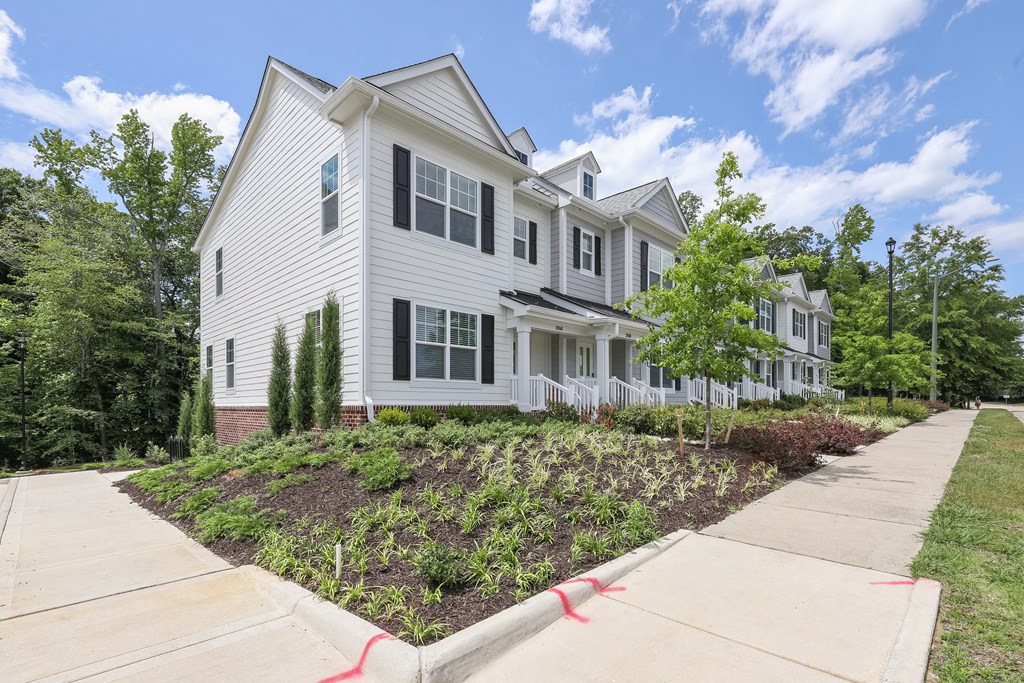 a white house with a sidewalk in front of it