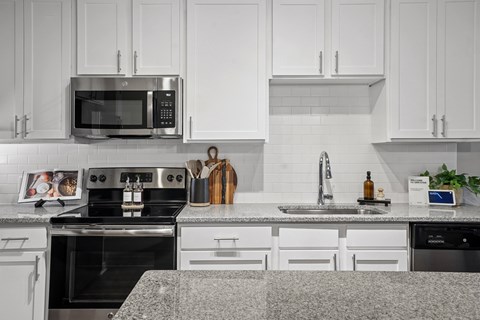 A modern kitchen with a stainless steel microwave above the stove.