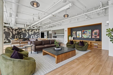 A modern living room with a dark wood coffee table and green velvet chairs.