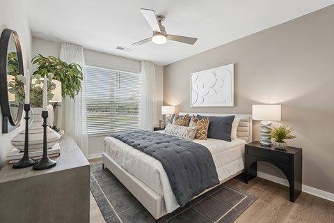 A bedroom with a large bed and a ceiling fan.