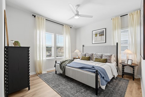 A bedroom with a large bed and a ceiling fan.