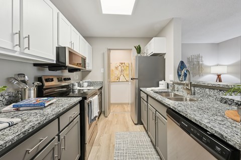 A kitchen with granite countertops and stainless steel appliances.