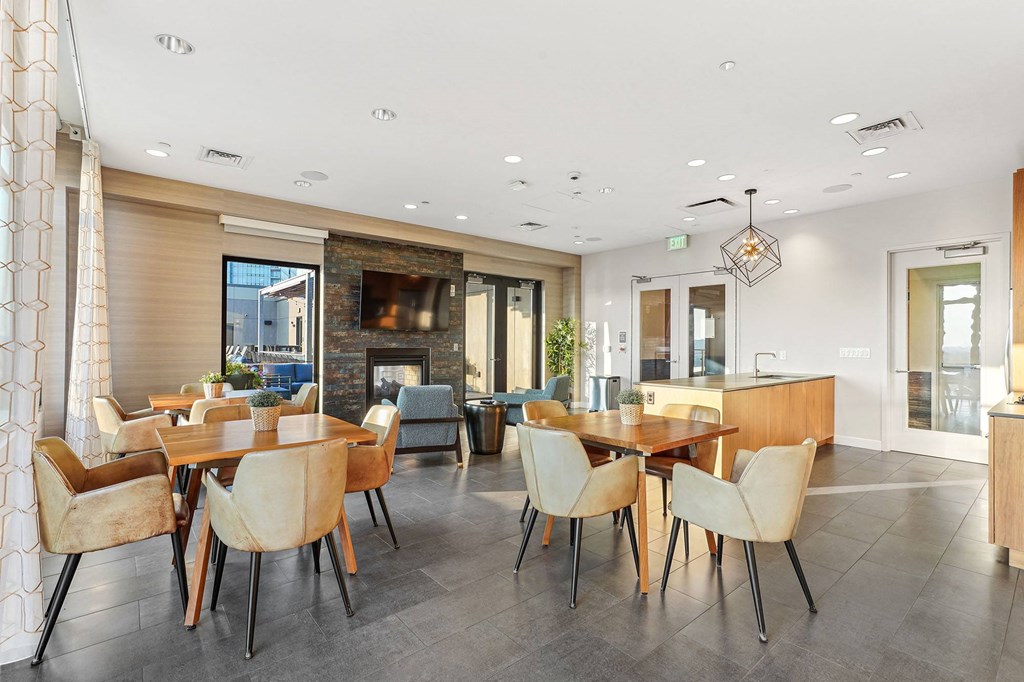 a dining area with tables and chairs and a living room with a fireplace