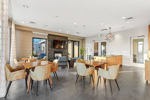 a dining area with tables and chairs and a living room with a fireplace