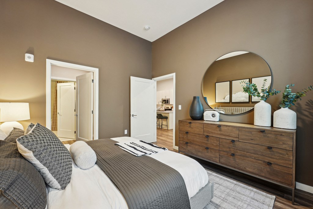 a bedroom with a bed and a dresser with a mirror