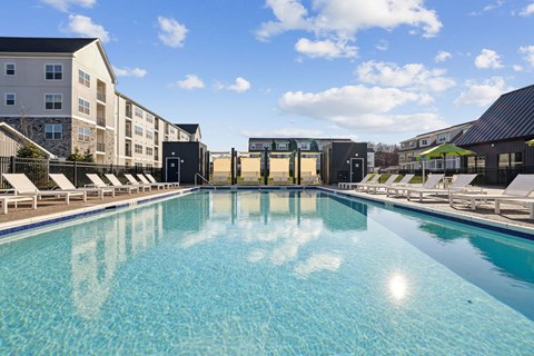 A large swimming pool in front of apartment buildings.