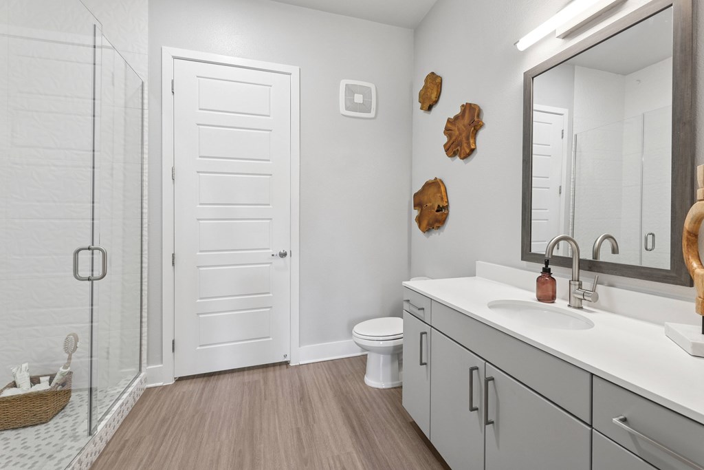 A bathroom with a white toilet, a white sink, and a white door.