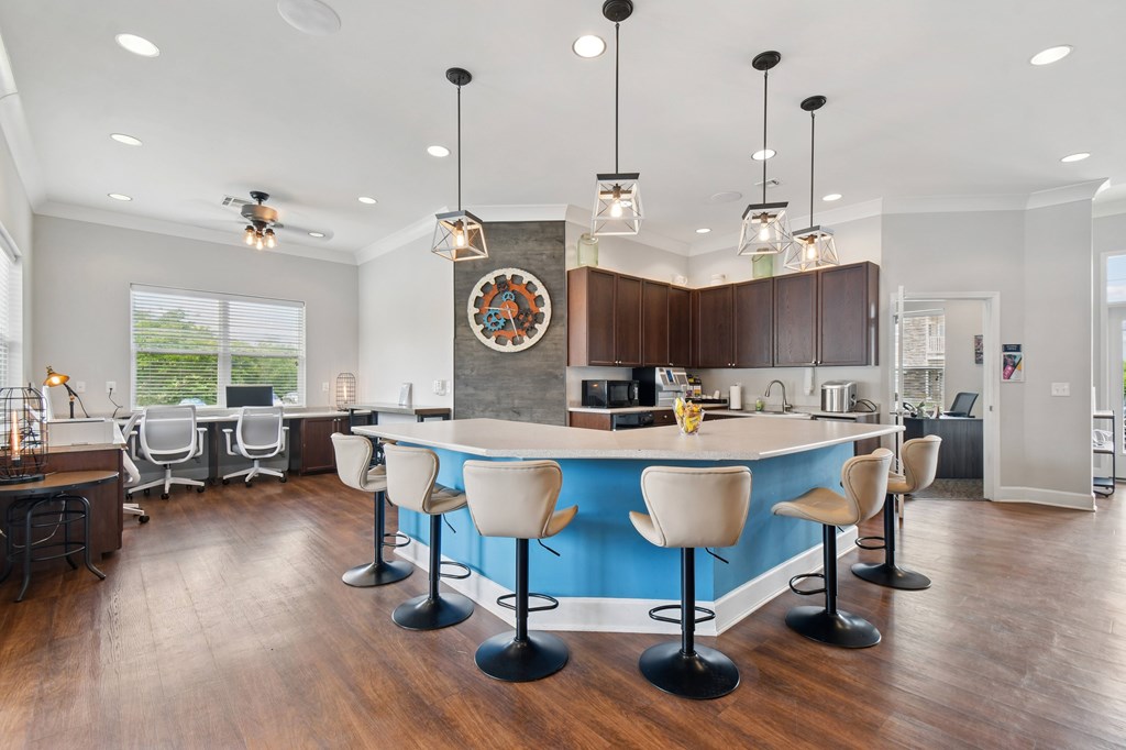 A kitchen with a blue counter and white chairs.