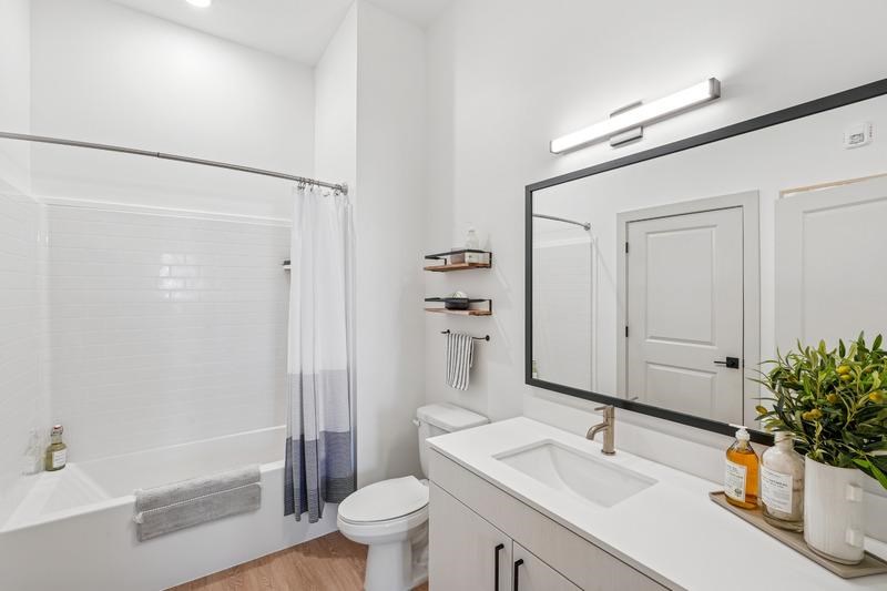 A white bathroom with a toilet, sink, and bathtub.