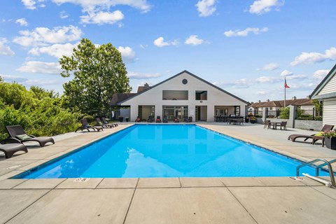 A large swimming pool in front of a house.