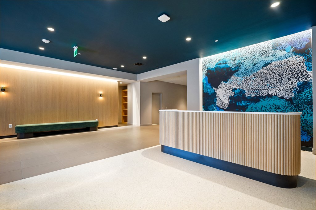 a lobby with a blue wall and a reception desk