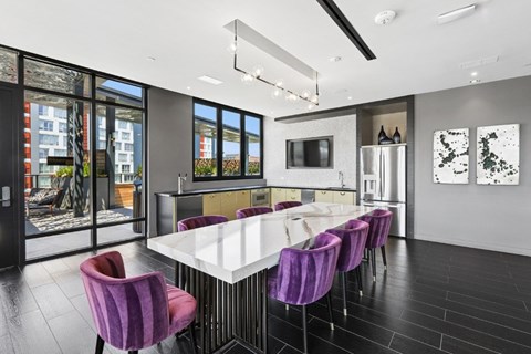 A modern dining room with purple chairs and a white table.