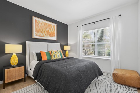 A bedroom with a large bed and a painting on the wall.