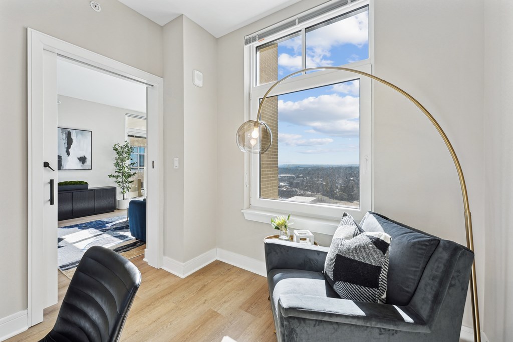 A living room with a grey couch and a black chair.