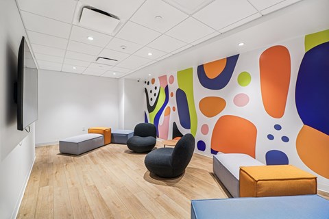 A room with a colorful wall and a wooden floor.