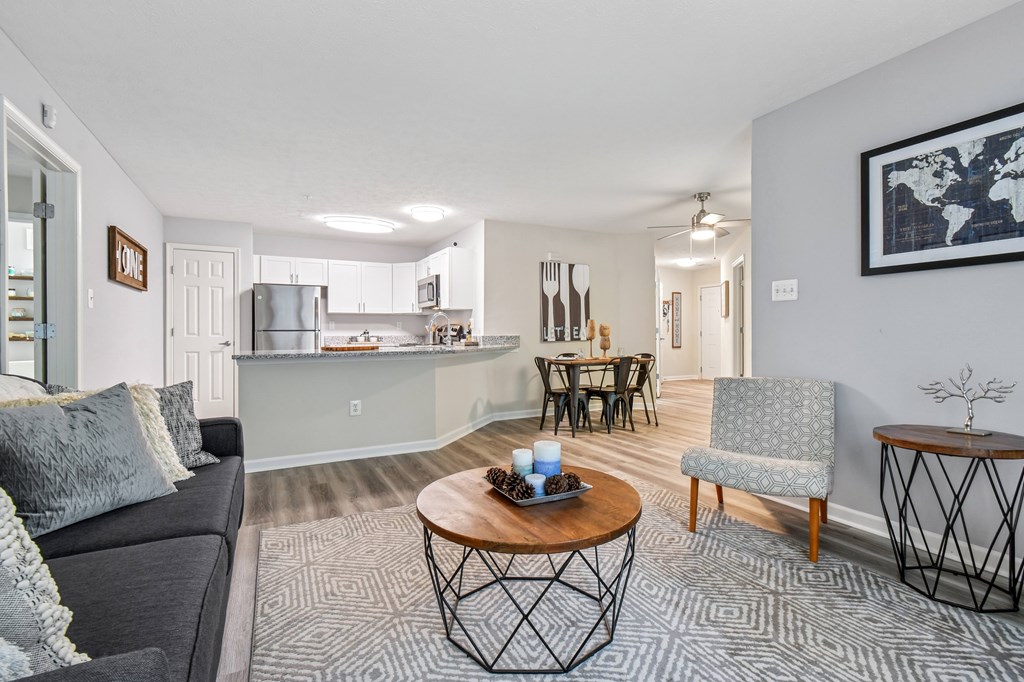 A living room with a grey couch, a coffee table, and a chair.