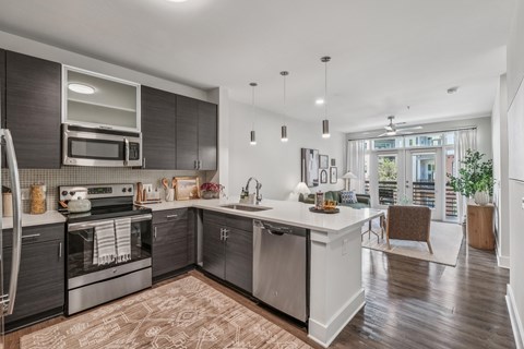 A modern kitchen with dark wood cabinets and stainless steel appliances.