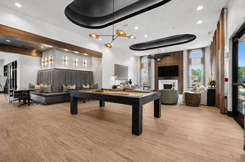A modern dining room with a long table and a grey sofa.