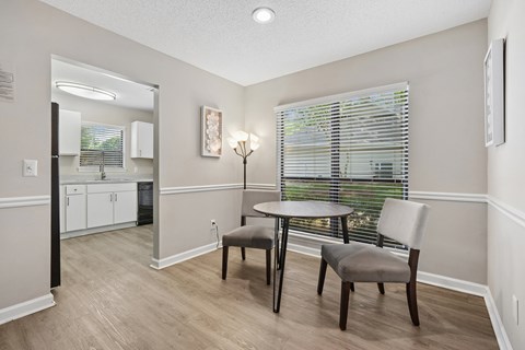 A dining room with a table and two chairs.