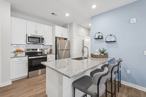 A kitchen with a granite countertop and stainless steel appliances.