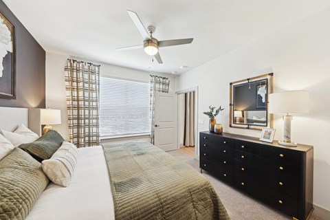 A bedroom with a large bed and a dresser.