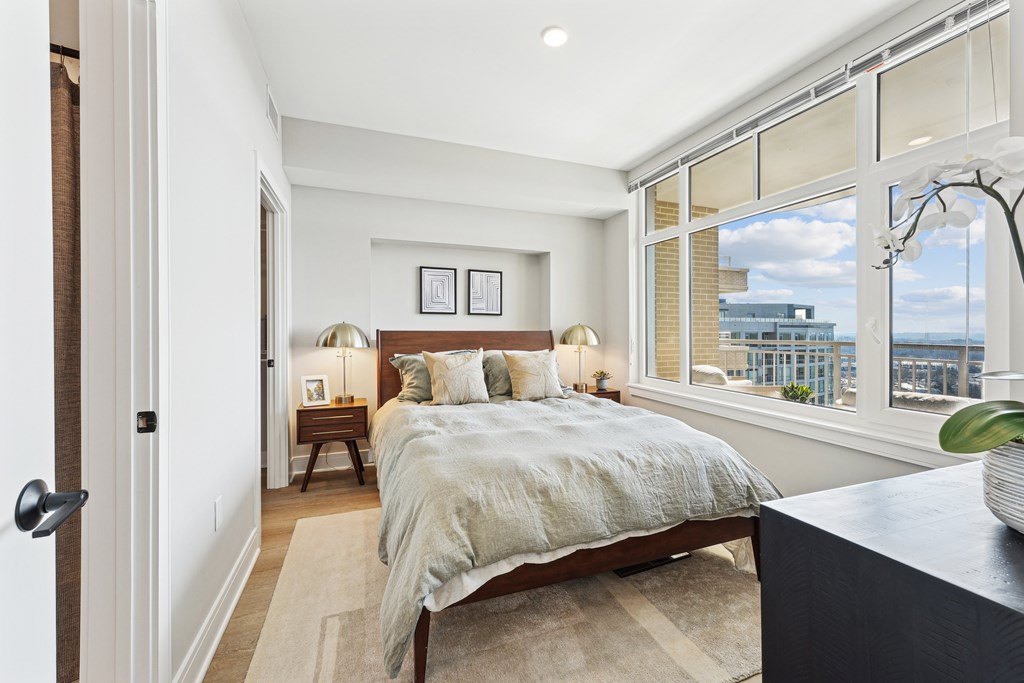 A bedroom with a large bed and a view of the city.