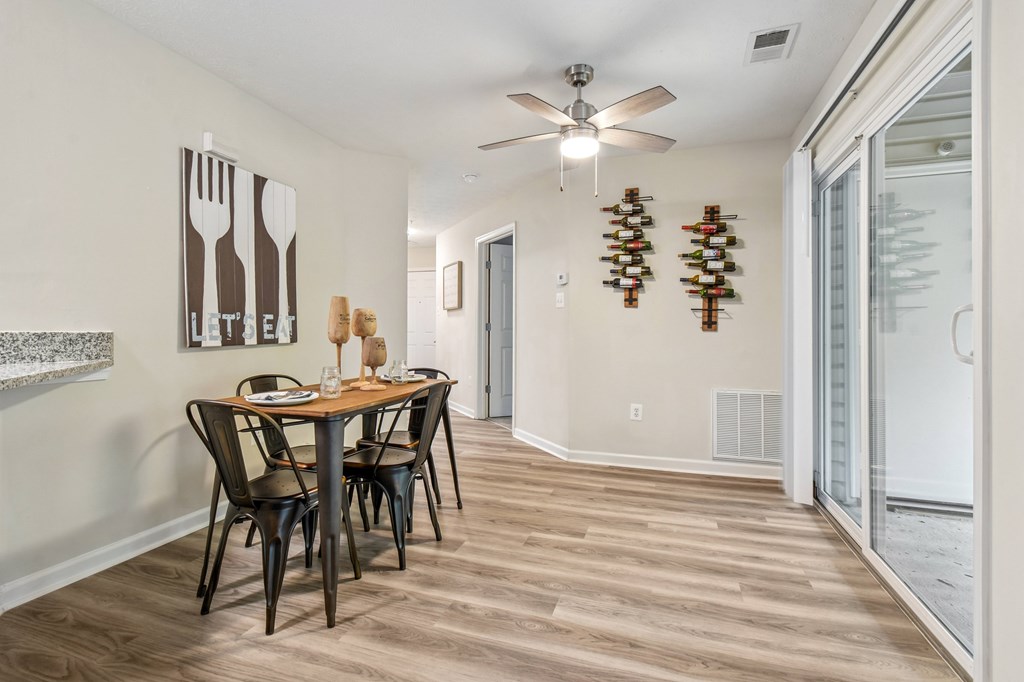 A dining room with a wooden table and chairs.