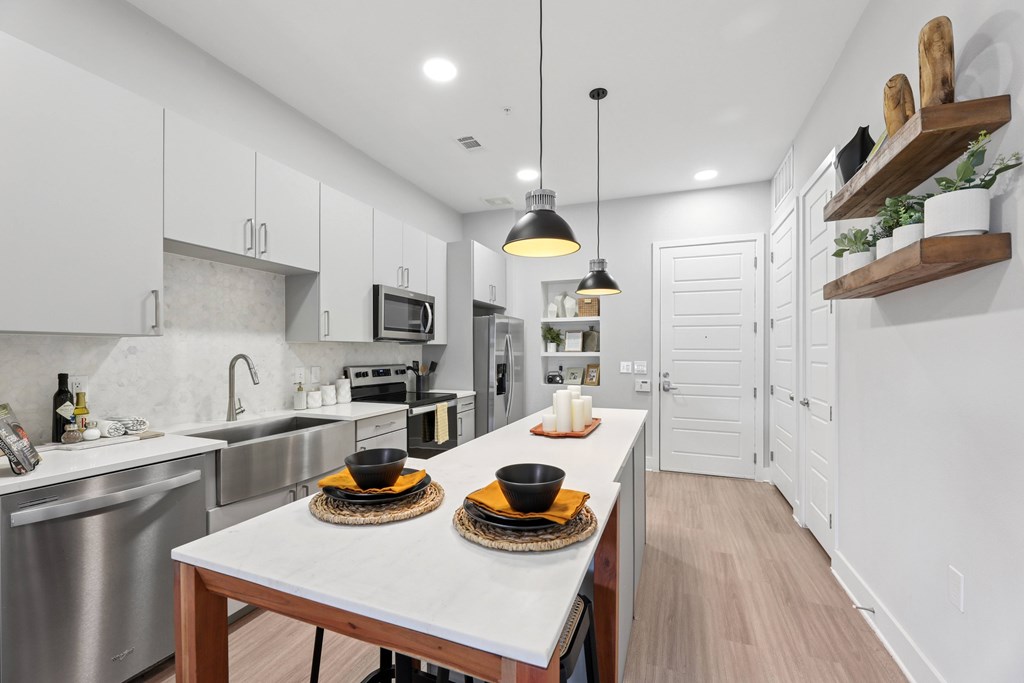 A modern kitchen with a dining table set for two.