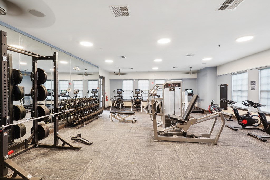 a gym with weights and cardio equipment in a building