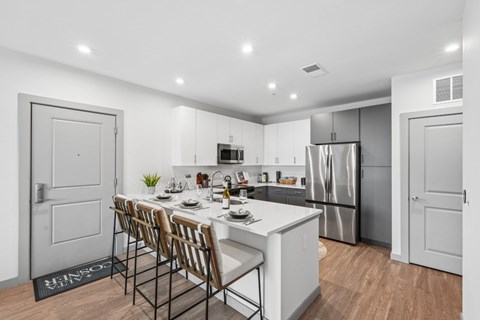 A modern kitchen with a dining table set for four.