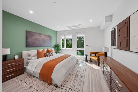 A bedroom with a large bed and a green wall.