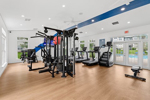 A gym with a variety of equipment including treadmills, weights, and exercise machines.