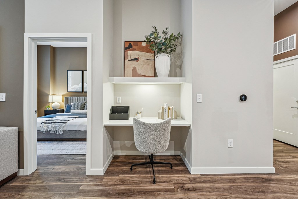 a desk with a chair in a room with a bed