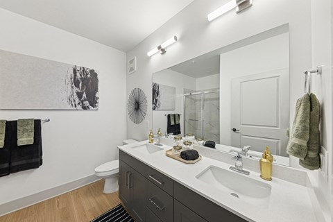 A bathroom with a white sink and a white toilet.