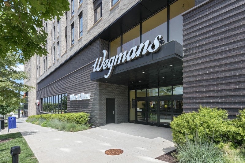 a walkway in front of a building with a large sign on the front of the building