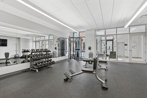 A gym with a variety of equipment including weights and machines.