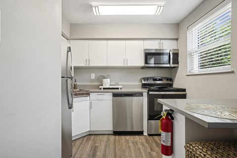 a kitchen with white cabinets and stainless steel appliances