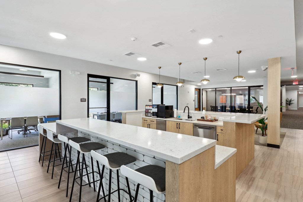 an open kitchen and dining area with white countertops and chairs