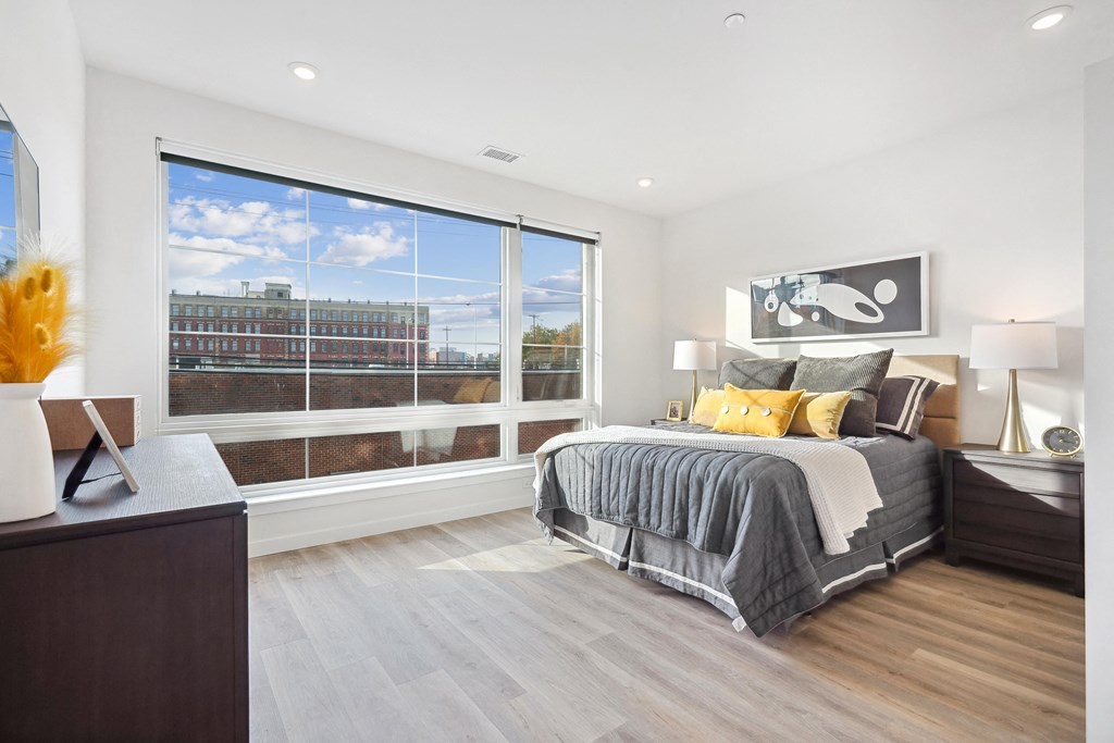 a bedroom with a large window and a bed
